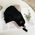 Detail of black trapper hat with beige faux fur lining and buckle strap on white table - M(56-58cm) / Black