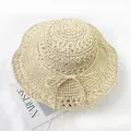 Top view of handwoven light beige straw sun hat with wavy brim and delicate ribbon bow - M (56-58cm) / Off White