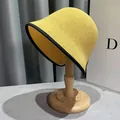 Vista dettagliata del cappello alla pescatora giallo in maglia con bordo nero - M / Giallo