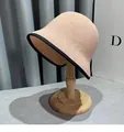 Dettaglio cappello a secchiello rosa chiaro intrecciato con bordo nero su supporto - M / Rosa