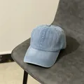 Détail d'une casquette de baseball en jean bleu clair sur un siège avec texture coton - M (56-58cm) / Denim clair