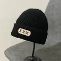 Detail of black knit beanie with a white patch featuring XXX embroidery and thick texture - M (56-58cm) / XXX Embroidery Patch Style / Black