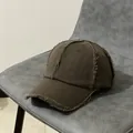 Dettaglio della visiera consumata su un cappello baseball vintage marrone scuro con frange - Regolabile / caffè