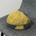 Dettaglio del berretto docker giallo e grigio con toppa vintage e bordi a taglio vivo - Regolabile / Giallo