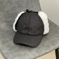 Dettaglio del cappello invernale con trapuntatura a cuore, paraorecchie e fiocco decorativo - M / Nero