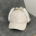 Dettaglio del cappello beige con trapuntatura a cuore e fodera in ecopelliccia - M / Bianco