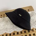 Primer plano de un sombrero de pescador negro con placa metálica dorada de detalle - M / Negro