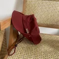 Detail of dark red outdoor bucket hat with metal MOMENT label and adjustable windproof cord - M / Burgundy