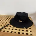 Dettaglio cappello alla pescatora nero con etichetta MOMENT, occhielli e cordino regolabile - M / Nero