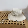Detail of ivory canvas bucket hat with MOMENT leather patch and windproof drawstring - M / White