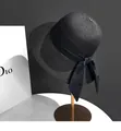 Detail of black straw sun hat showing dense woven texture and elegant silk ribbon bow - M (56-58cm) / Black