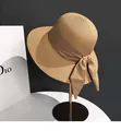 Detail of a khaki woven straw hat featuring an elegant silk bow on a metal stand - M (56-58cm) / Khaki