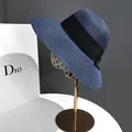 Detail of blue straw sun hat with wide brim and elegant black ribbon on a gold stand - M(56-58cm) / Navy Blue