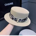 Dettaglio della paglia del cappello beige con nastro floreale e perle bianche - M (56-58cm) / Beige