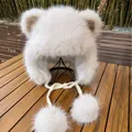 Dettaglio del cappello invernale in finta pelliccia bianca con orecchie e pompon soffici - M(56-58cm) / Bianco