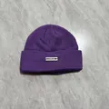 Dettaglio del berretto in maglia a coste viola con etichetta bianca FRCCDOM cucita - M / Viola