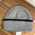 Dettaglio del berretto in maglia grigia spessa con bordo smerlato nero su legno - M（56-58cm） / Grigio scuro