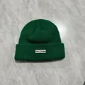 Dettaglio del berretto in maglia verde scuro con patch freedom bianca su trama spessa - M / Verde