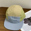 Detail of multi-color five-panel camp cap with breathable eyelets on wooden table - M (56-58cm) / Khaki