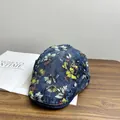 Dettaglio ravvicinato del cappellino in denim lavato vintage con stampa floreale su legno - M (56-58cm) / Blu scuro