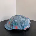 Gorra retro de denim azul claro con estampados de flores y mariposas sobre madera - Azul claro