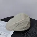 Dettaglio della coppola in twill di cotone grigio chiaro su un tavolo di legno nero - M (56-58cm) / Beige