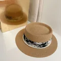 Close-up of khaki boater hat featuring a black and white ink-style ribbon and white pearls - M (56-58cm) / Camel