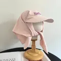 Detail of pink plaid sun hat with neck protection and Freedom patch on wooden stand - M (56-58cm) / Pink