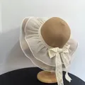 Detailed close-up of straw sun hat featuring wavy organza brim and large lace bow decoration - M (56-58cm) / Khaki