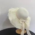 Detailed view of wide brim straw hat with organza ruffles and delicate lace ribbon ties - M (56-58cm) / White
