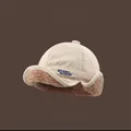 Detail view of corduroy earflap hat with lamb wool lining and Never Give Up embroidery - M (56-58cm) / Beige