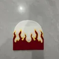 Dettaglio di un berretto in maglia con motivo a fiamme rosse e parte superiore bianca - M / Bianco - Fiamma Rossa / 56-58cm