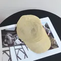 Detailed top view of breathable beige woven texture straw baseball cap on magazine - M (56-58cm) / Beige
