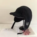 Detailansicht der schwarzen Lammfell-Fliegermütze mit weißem geometrischem Logo-Stick - M / Schwarz