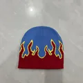 Dettaglio del motivo a fiamma lavorato a maglia sul berretto blu e rosso vivace - M / Blu - Fiamma Rossa / 56-58cm