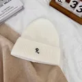 Detail of white ribbed beanie with elegant black letter R embroidery and warm wool texture - M / White