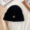 Detalle del gorro de punto acanalado negro con bordado de gato blanco y textura suave - M / Negro