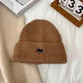Detalle de textura de gorro de punto grueso color camello con bordado de alce - M(56-58cm) / Caqui