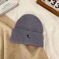 Close-up of lavender knit beanie featuring vertical ribbing and black letter R embroidery - M / Light Purple