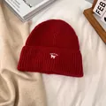Detalle de gorro de punto rojo con bordado de gato blanco y el texto IT'S A CAT - M / Burdeos