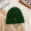 Detailed view of dark green ribbed knit beanie featuring a white letter R embroidery - M / Dark Green
