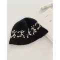 Vista detallada de un gorro de punto negro con patrón blanco y textura suave - M (56-58cm) / Negro