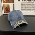 Detail of distressed brim on washed blue denim baseball cap with yellow MADTIME embroidery - M / Denim Dark Blue