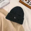 Detailed close-up of dark grey ribbed knit beanie featuring a white embroidered letter R - M / Dark Gray