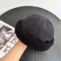 Dettaglio del cappello docker nero in tessuto antivento con caldo bordo in lana d'agnello - M / Nero