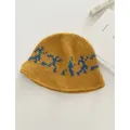 Detalle del sombrero de punto amarillo mostaza con figuras bordadas en color azul - M (56-58cm) / Amarillo