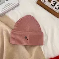 Detail of pink ribbed knit beanie with deep blue embroidered R letter on a folded brim - M / Pink
