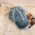 Dettaglio di un berretto da baseball in denim azzurro con bordi sfilacciati e cuciture - M (56-58cm) / Azzurro