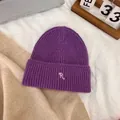 Detail of purple ribbed knit beanie featuring a white embroidered R letter logo - M / Deep purple