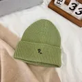 Close-up of grass green knitted beanie with detailed R letter embroidery and rib texture - M / Light Green